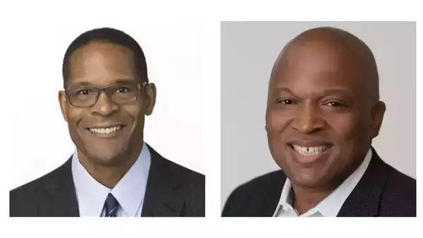 Two smiling Black men in professional headshots. The man on the left wears glasses, a dark pinstripe suit, and blue shirt. The bald man on the right wears a dark suit jacket and white shirt.